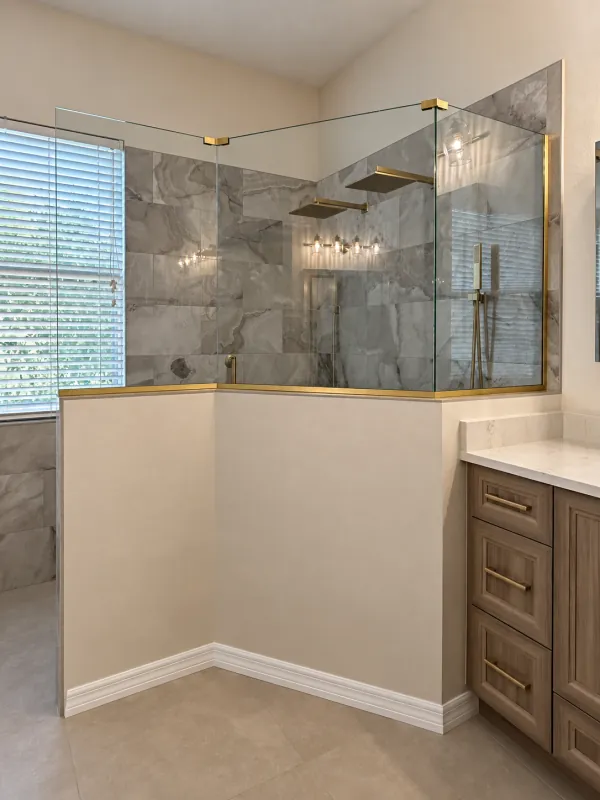 Clear corner glass above a half wall with brass fittings