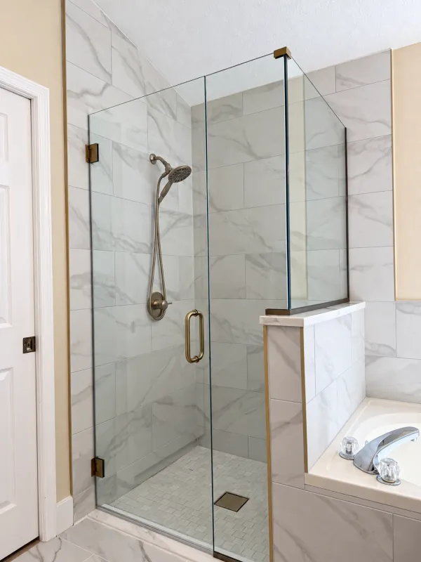 Brass-hardware shower with glass over a half wall