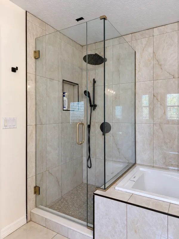 Clear corner shower beside a built-in bathtub
