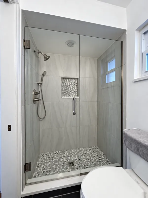 Frameless alcove shower with a penny-tile floor