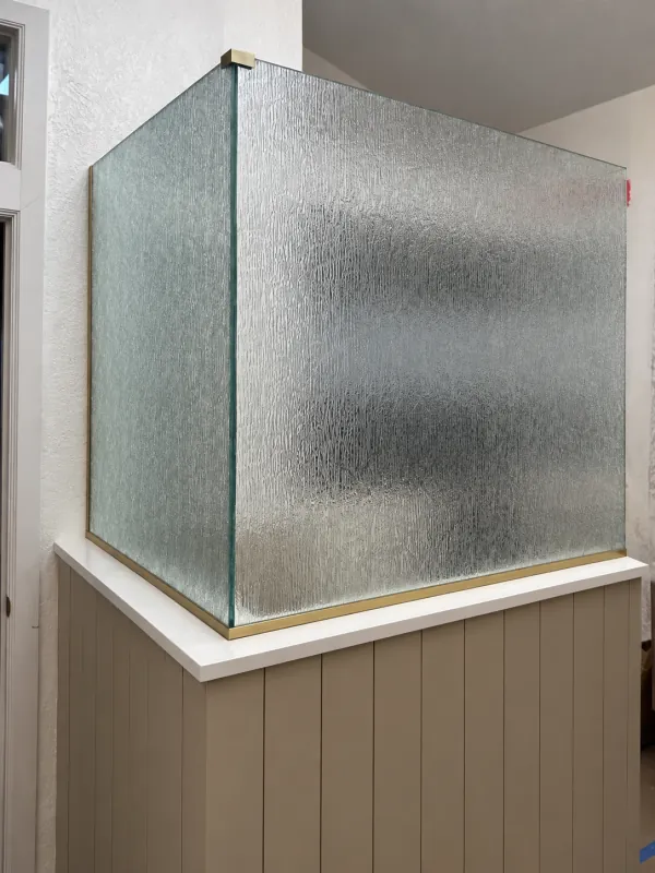 Textured corner glass above a paneled half wall